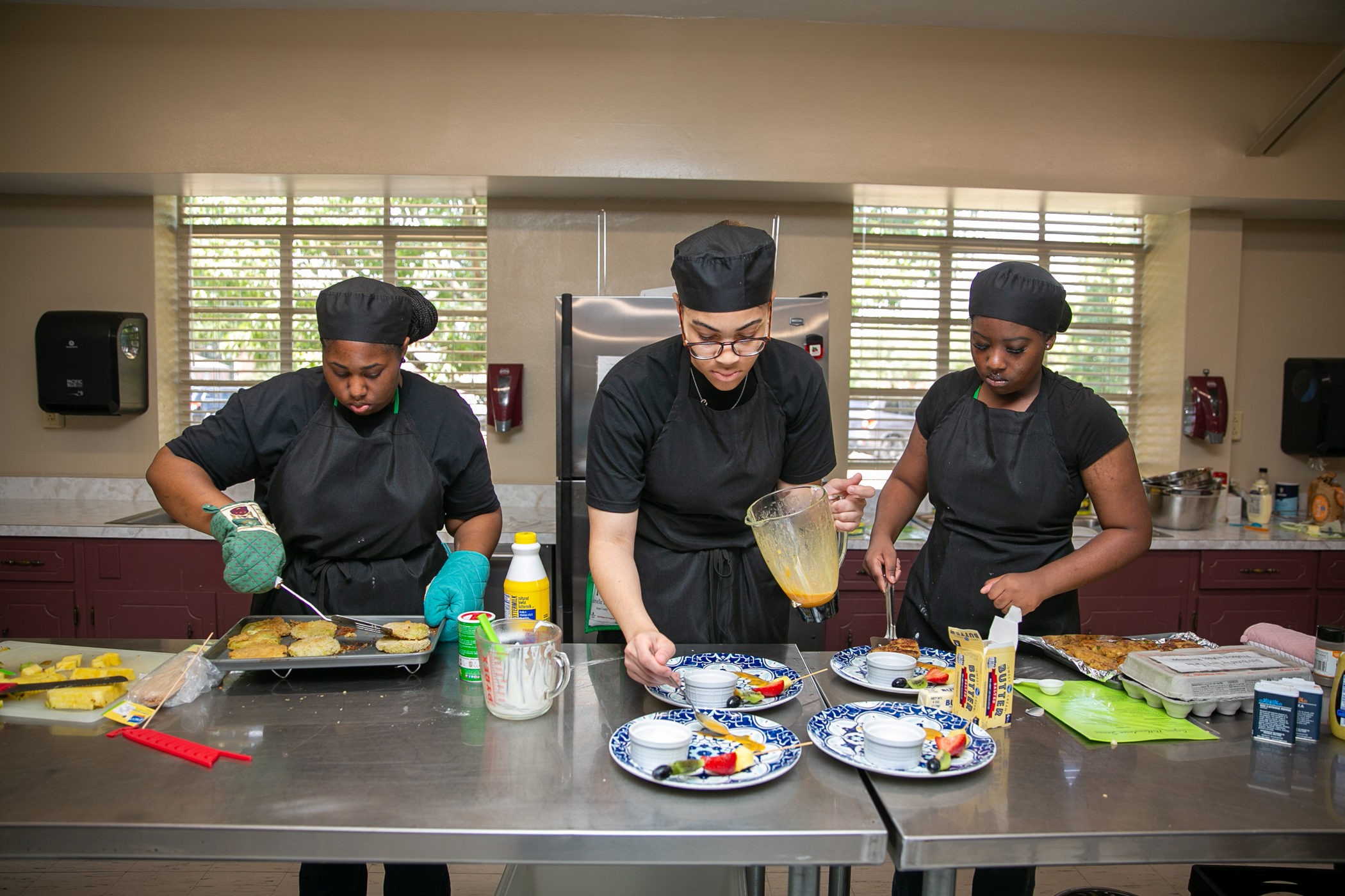 Three students cooking.