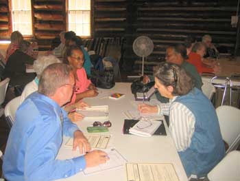 Five people sitting around a table talking.