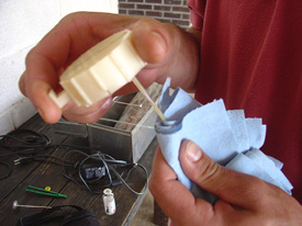 The cutting tool is a round, flat, plastic device with a small hole to insert the tip of the straw. You push a button on the device to cut the tip of the straw.