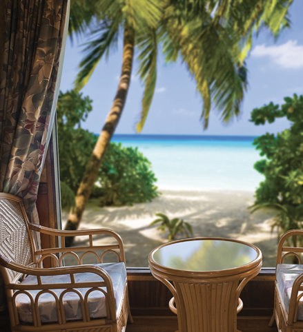 An indoor seating area looking out at a sandy beach.