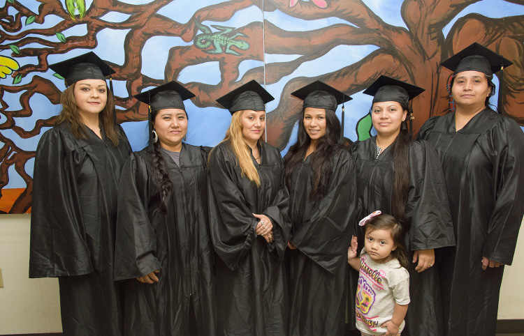 A group of Hispanic graduates in caps and gowns.