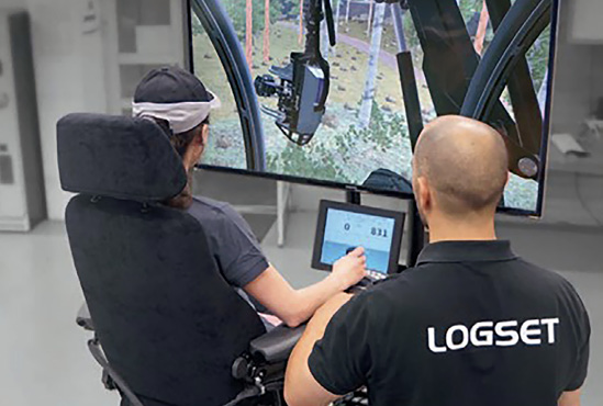 A student sits in a simulator while a trainer provides instructions.