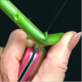 Woman cutting stem improperly. She is bending the stem over the blade.