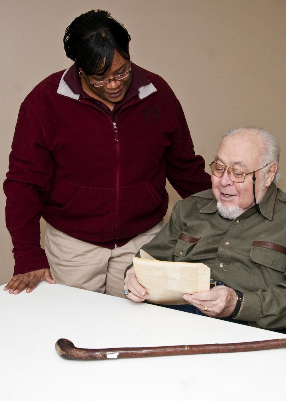 Clay County 4-H agent Fran Brock and volunteer leader Norman Armstrong look over one of his old scripts from a radio program he did as a member and leader to promote 4-H involvement. (Photo by MSU Ag Communications/Scott Corey)