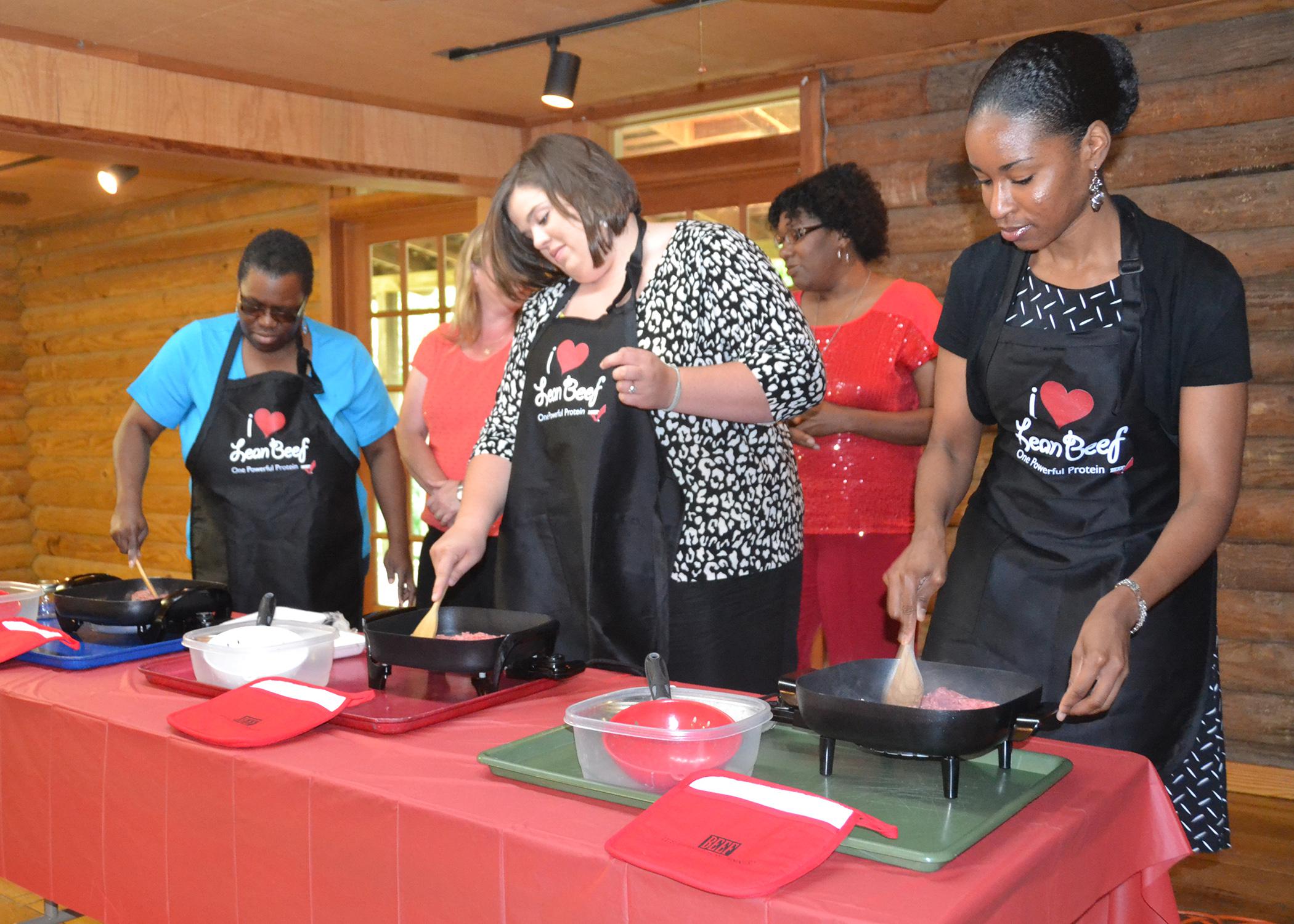 Terri Thompson, Jackson County Extension family and consumer sciences agent (from left); Jennifer Williams, Webster County Extension family and consumer sciences agent and Cassandra Kirkland, Extension family life specialist, cook ground beef during a demonstration at a professional development session held in Jackson on July 16, 2013.  (Photo by MSU Ag Communications/Susan Collins-Smith)