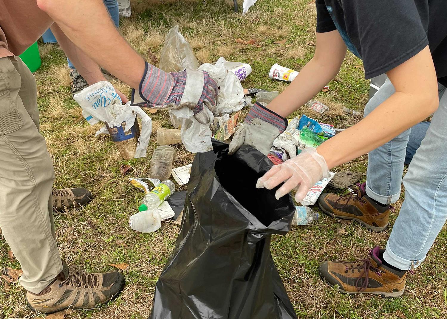 People put trash into a trash bag.