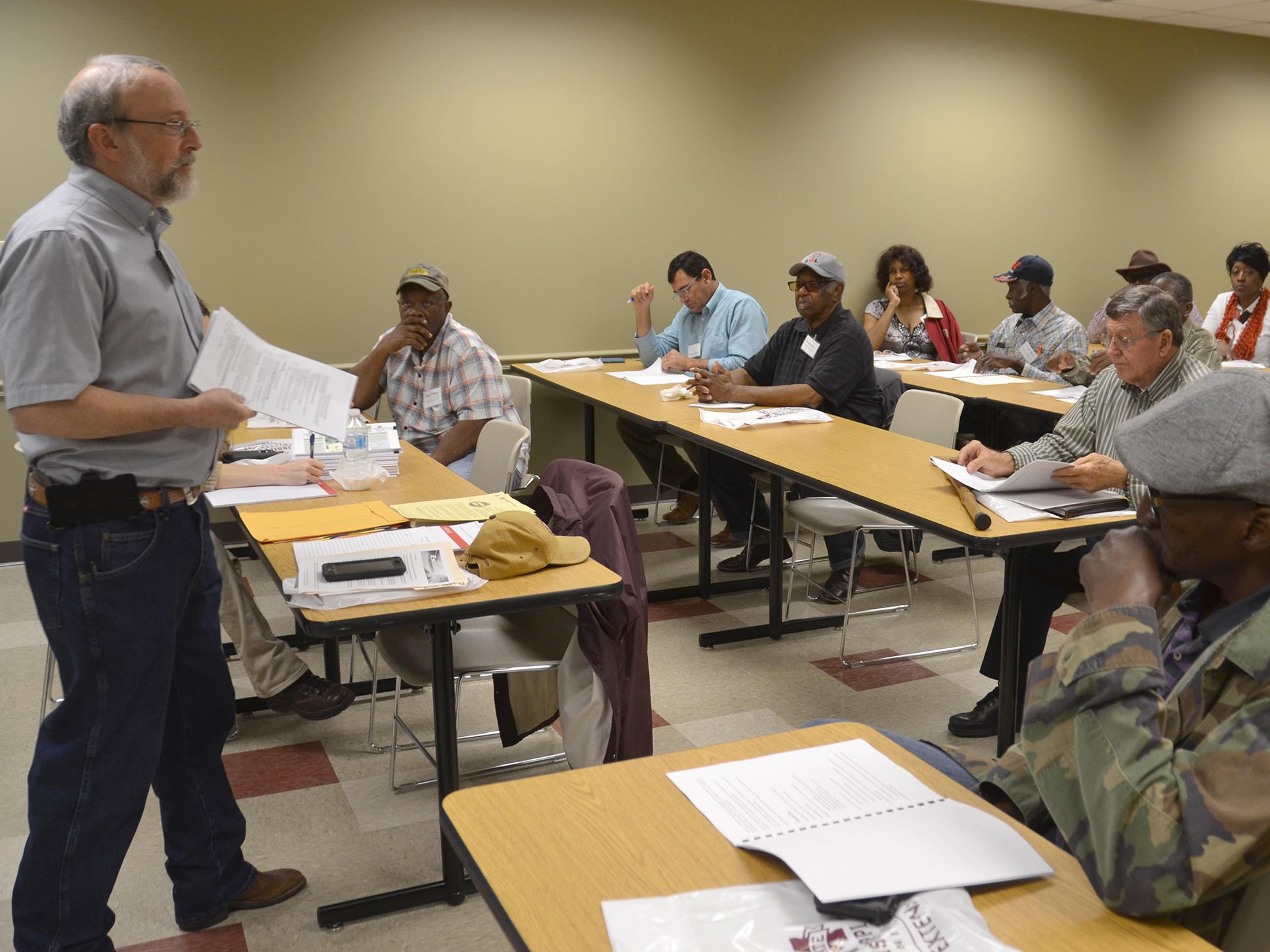 A Mississippi State University specialist stands before a room of seated meeting participants.