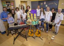 A group of people surround more than 20 musical instruments.