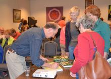 Horticulturist Rick Darke signs copies of his latest book for audience members after his presentation on balancing beauty and function in the home landscape March 28, 2015, in Picayune, Mississippi. Darke was the 2015 Mississippi State University Crosby Arboretum Lecture Series speaker. (Photo by MSU Ag Communications/Susan Collins-Smith)