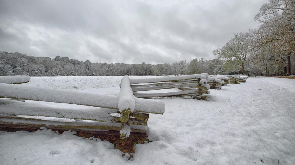 snow covers a fence and field in south Mississippi.