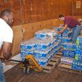 B.J. McClenton, Monroe County Extension director (left), and Charlie Stokes, area Extension agent (right), unload water from a semi-trailer to distribute to tornado victims in Monroe County. MSU Extension Service employees are storing and distributing supplies to those affected by the April 26 and 27 tornadoes. (Photo by Scott Corey)