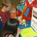 Monica Morel, Hancock County robotics club volunteer leader, helps Luke and Rebekah Schilling of Oktibbeha County with a robot during 4-H Day at the Mississippi State Fair in Jackson on Oct. 13. The robotics exhibit was one of several hands-on science activities available to visitors. (Photo by MSU Ag Communications/Susan Collins-Smith)