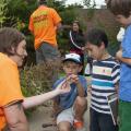 Jennifer Seltzer, a research associate with the Mississippi Entomological Museum at Mississippi State University, talks to Jameson Clancy, sitting, Thomas Taylor and Simon Smith about a grasshopper they found during the BioBlitz Sept. 13, 2014, at the Mississippi Museum of Natural Science. The 13-hour event helped educate the public about local ecosystems. (Photo by MSU Ag Communications/Kat Lawrence)