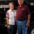 A man and woman stand next to each other smiling.