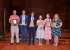 A group of people holding awards.