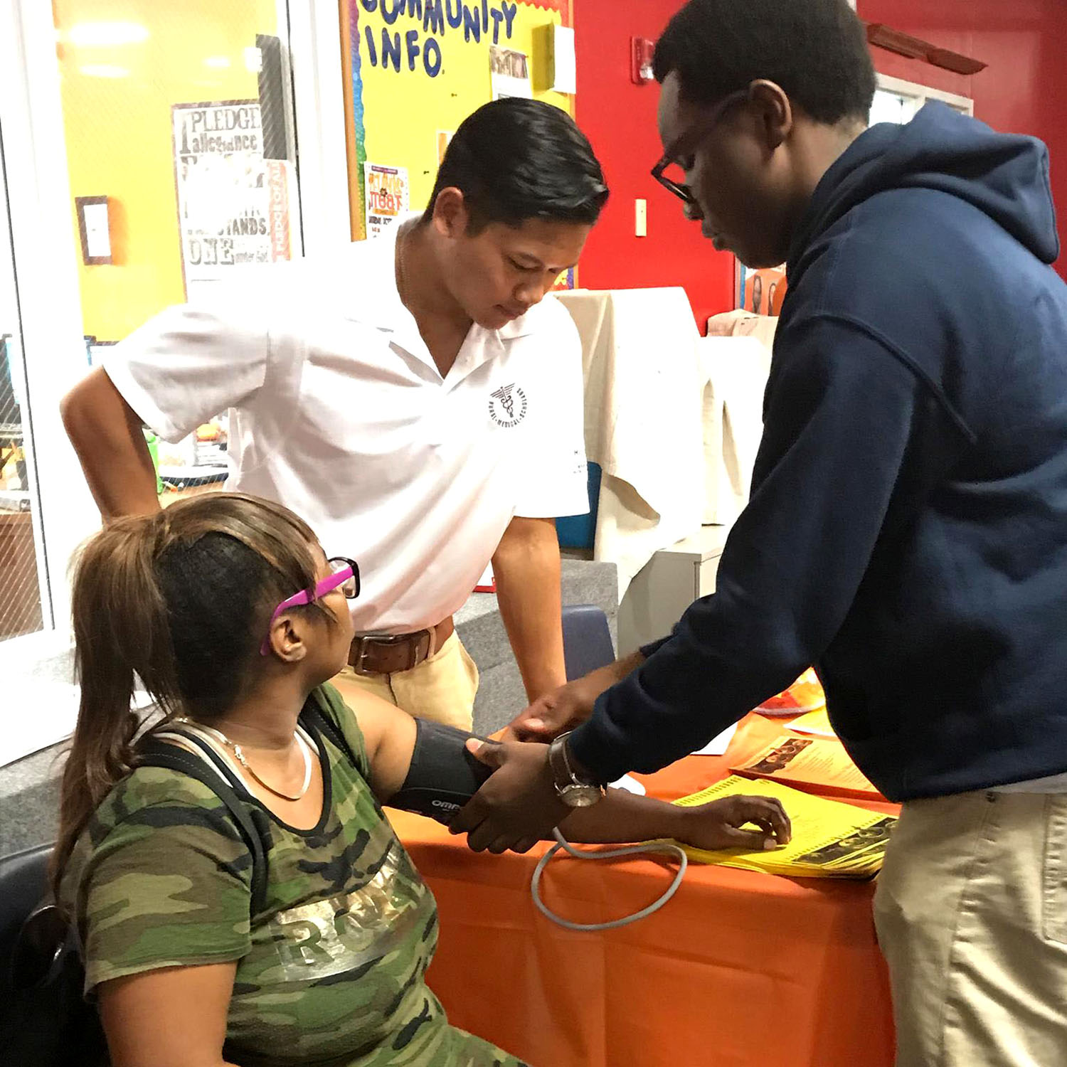 Carey takes blood pressure while Daniel looks on